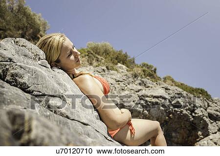 Woman lying on rocks wearing bikini at Krokos Beach, Psili Ammos, Greece View Large Photo Image Stock Image - Woman lying on rocks wearing bikini at Krokos Beach, Psili Ammos, Greece. Fotosearch