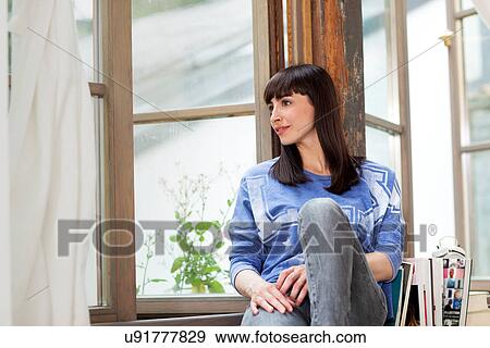 Stock Photo - Woman on windowsill. Fotosearch