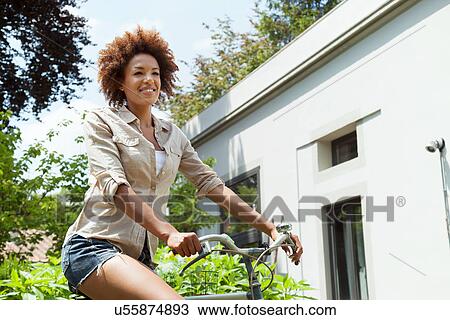 Woman riding bicycle, low angle View Large Photo Image Stock Image - Woman riding bicycle, low angle. Fotosearch