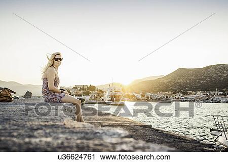 Stock Image - Woman sitting at coast at Pythagoreio, Samos, Greece. Fotosearch