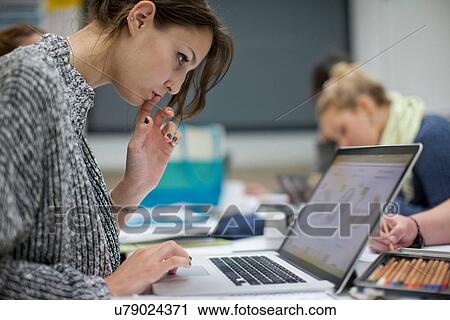 Woman using laptop in art class View Large Photo Image Stock Image - Woman using laptop in art class. Fotosearch