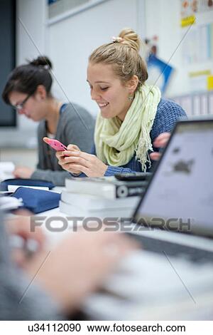 Woman using smartphone in classroom View Large Photo Image Stock Image - Woman using smartphone in classroom. Fotosearch