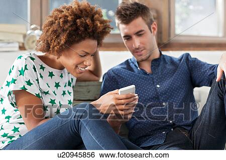 Woman using smartphone, man watching View Large Photo Image Stock Photograph - Woman using smartphone, man watching. Fotosearch