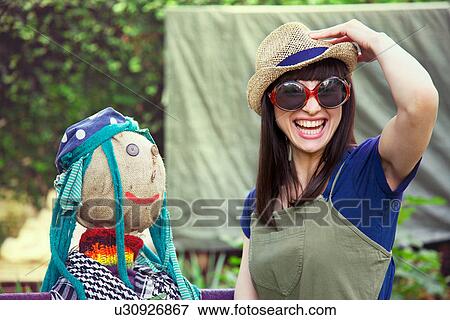 Woman wearing sunglasses and hat with scarecrow View Large Photo Image Stock Photo - Woman wearing sunglasses and hat with scarecrow. Fotosearch