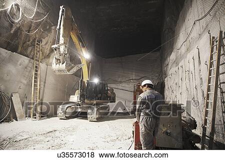 Worker and excavator in a marble quarry View Large Photo Image Stock Photo - Worker and excavator in a marble quarry. Fotosearch