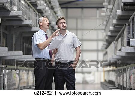 Worker and manager checking products in engineering warehouse View Large Photo Image Stock Image - Worker and manager checking products in engineering warehouse. Fotosearch