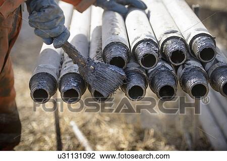 Worker preparing drilling rig connections with oil View Large Photo Image Stock Image - Worker preparing drilling rig connections with oil. Fotosearch
