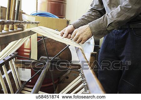 Picture - Worker using loom in wool factory, cropped. Fotosearch