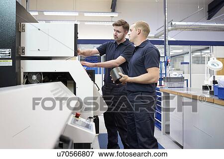 Workers checking control panel in engineering factory View Large Photo Image Stock Photo - Workers checking control panel in engineering factory. Fotosearch