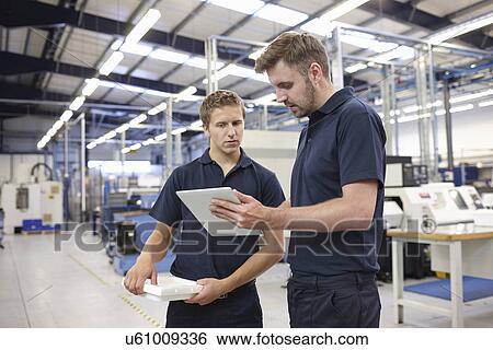 Workers checking order in engineering factory View Large Photo Image Stock Photograph - Workers checking order in engineering factory. Fotosearch