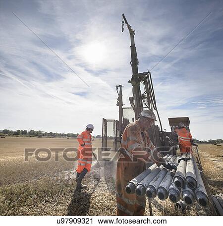 Workers operating drilling rig in field View Large Photo Image Stock Image - Workers operating drilling rig in field. Fotosearch