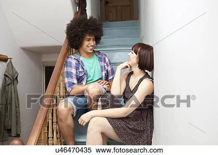 Stock Photography - Young couple chatting on stairs. Fotosearch