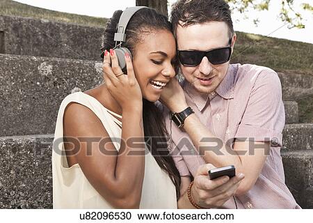 Young couple listening to music together View Large Photo Image Stock Image - Young couple listening to music together. Fotosearch