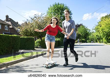 Young couple practicing on skateboard View Large Photo Image Stock Image - Young couple practicing on skateboard. Fotosearch