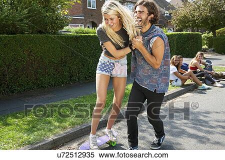 Young couple practicing with skateboard View Large Photo Image Stock Photography - Young couple practicing with skateboard. Fotosearch
