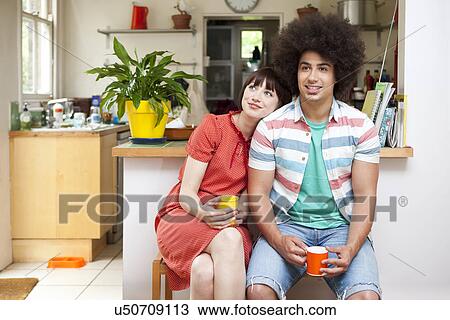 Young couple sitting in kitchen View Large Photo Image Stock Image - Young couple sitting in kitchen. Fotosearch