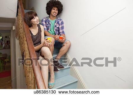 Young couple sitting on stairs View Large Photo Image Stock Image - Young couple sitting on stairs. Fotosearch