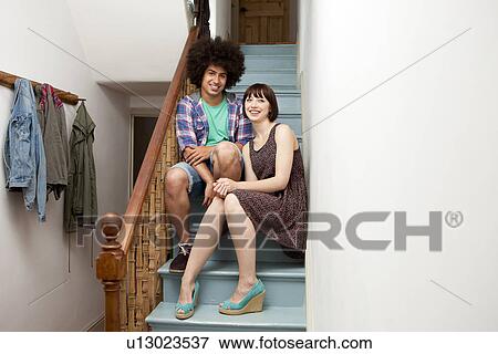 Stock Photo - Young couple sitting together on stairs. Fotosearch
