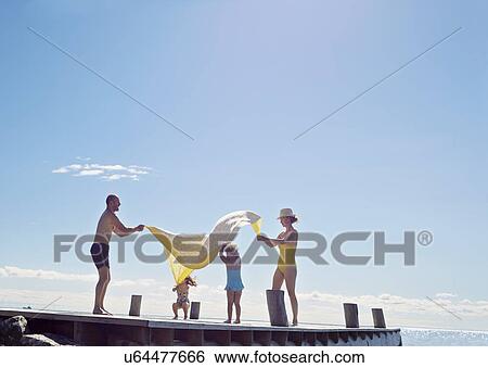 Stock Photograph - Young family having fun on pier, Utvalnas, Gavle, Sweden. Fotosearch