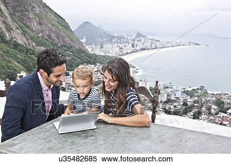 Young family using laptop, Casa Alto Vidigal, Rio De Janeiro, Brazil View Large Photo Image Stock Photography - Young family using laptop, Casa Alto Vidigal, Rio De Janeiro, Brazil. Fotosearch