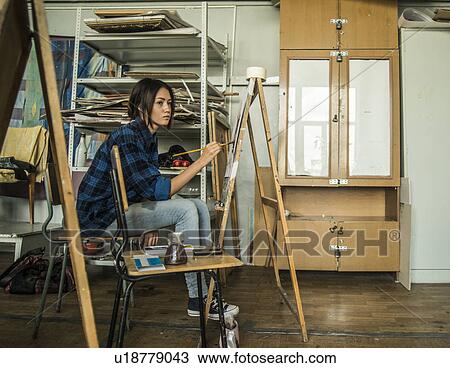 Young female artist painting in studio View Large Photo Image Stock Image - Young female artist painting in studio. Fotosearch