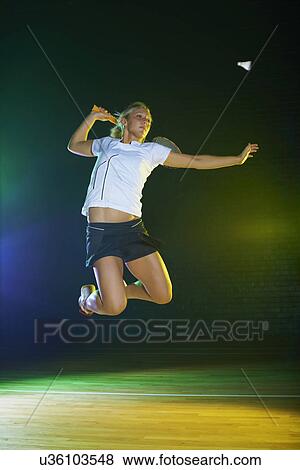 Young female badminton player mid air on court View Large Photo Image Stock Photo - Young female badminton player mid air on court. Fotosearch