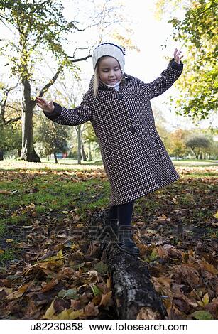 Young girl balancing on log in autumn, London, England, UK View Large Photo Image Stock Photo - Young girl balancing on log in autumn, London, England, UK. Fotosearch