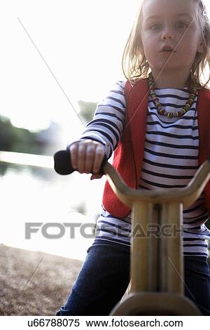 Stock Photography - Young girl on tricycle. Fotosearch