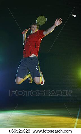 Young male badminton player mid air on court View Large Photo Image Stock Image - Young male badminton player mid air on court. Fotosearch