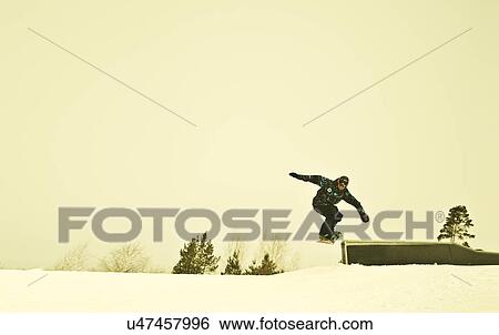 Young male snow boarder mid air on mountain View Large Photo Image Stock Photograph - Young male snow boarder mid air on mountain. Fotosearch