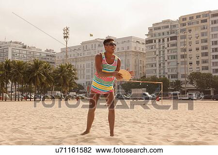 Young man about to hit ball with bat on Copacabana Beach, Rio de Janeiro, Brazil View Large Photo Image Stock Image - Young man about to hit ball with bat on Copacabana Beach, Rio de Janeiro, Brazil. Fotosearch