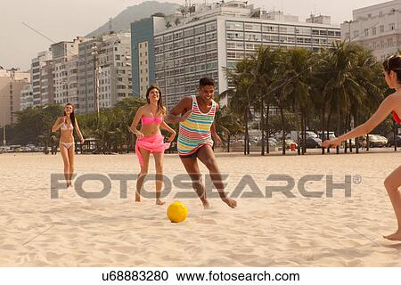 Young man and women playing football on beach, Copacabana Beach, Rio De Janeiro, Brazil View Large Photo Image Stock Image - Young man and women playing football on beach, Copacabana Beach, Rio De Janeiro, Brazil. Fotosearch