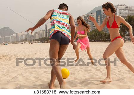 Young man and women playing football on Copacabana Beach, Rio De Janeiro, Brazil View Large Photo Image Stock Photo - Young man and women playing football on Copacabana Beach, Rio De Janeiro, Brazil. Fotosearch