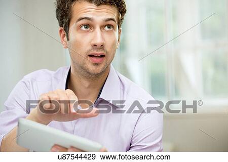 Stock Photo - Young man explaining with digital tablet. Fotosearch