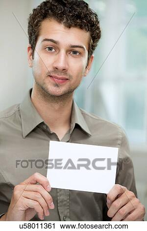 Stock Image - Young man holding white card. Fotosearch