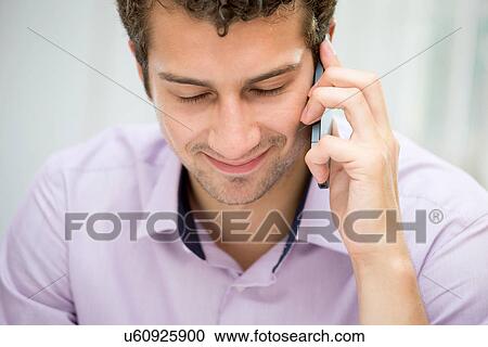 Stock Image - Young man on mobile phone. Fotosearch