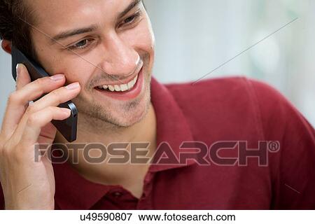 Stock Photo - Young man on mobile phone. Fotosearch