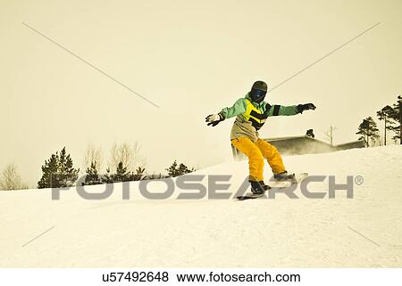 Young man snow boarding on mountain View Large Photo Image Stock Photo - Young man snow boarding on mountain. Fotosearch