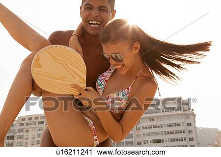 Young man swinging woman in arms View Large Photo Image Stock Image - Young man swinging woman in arms. Fotosearch