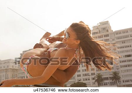 Young man swinging woman in arms View Large Photo Image Stock Photograph - Young man swinging woman in arms. Fotosearch