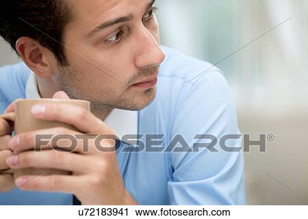 Stock Image - Young man taking coffee break. Fotosearch