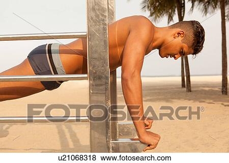 Young man working out on beach View Large Photo Image Stock Photo - Young man working out on beach. Fotosearch