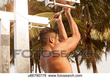 Stock Photo - Young man working out on beach. Fotosearch