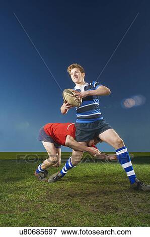 Stock Photo - Young men playing rugby. Fotosearch