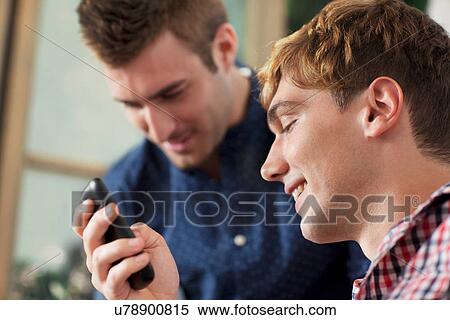 Young men using smartphone View Large Photo Image Stock Photography - Young men using smartphone. Fotosearch