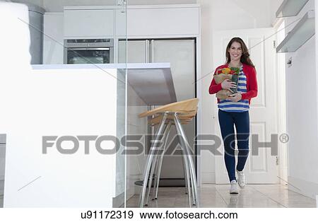 Young woman carrying grocery bag View Large Photo Image Stock Photo - Young woman carrying grocery bag. Fotosearch