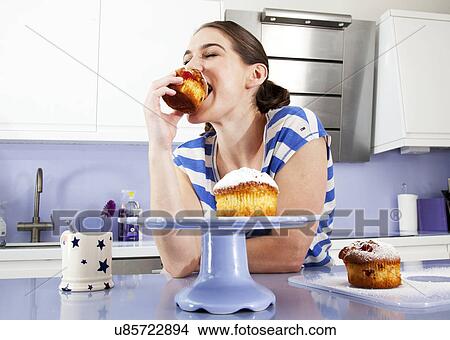 Young woman eating muffin View Large Photo Image Picture - Young woman eating muffin. Fotosearch