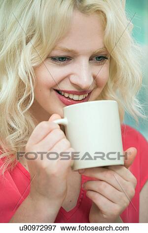 Young woman enjoying a hot drink View Large Photo Image Stock Photo - Young woman enjoying a hot drink. Fotosearch