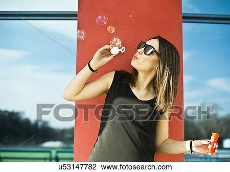 Young woman having fun blowing bubbles View Large Photo Image Stock Image - Young woman having fun blowing bubbles. Fotosearch