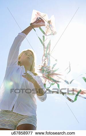 Young woman holding kite, Utvalnas, Gavle, Sweden View Large Photo Image Stock Photo - Young woman holding kite, Utvalnas, Gavle, Sweden. Fotosearch
